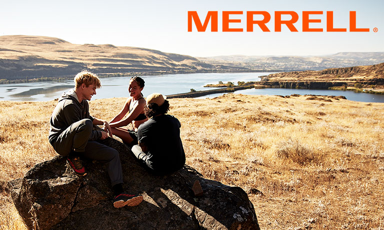 Merrell athletes sitting on a rock wearing Merrell footwear